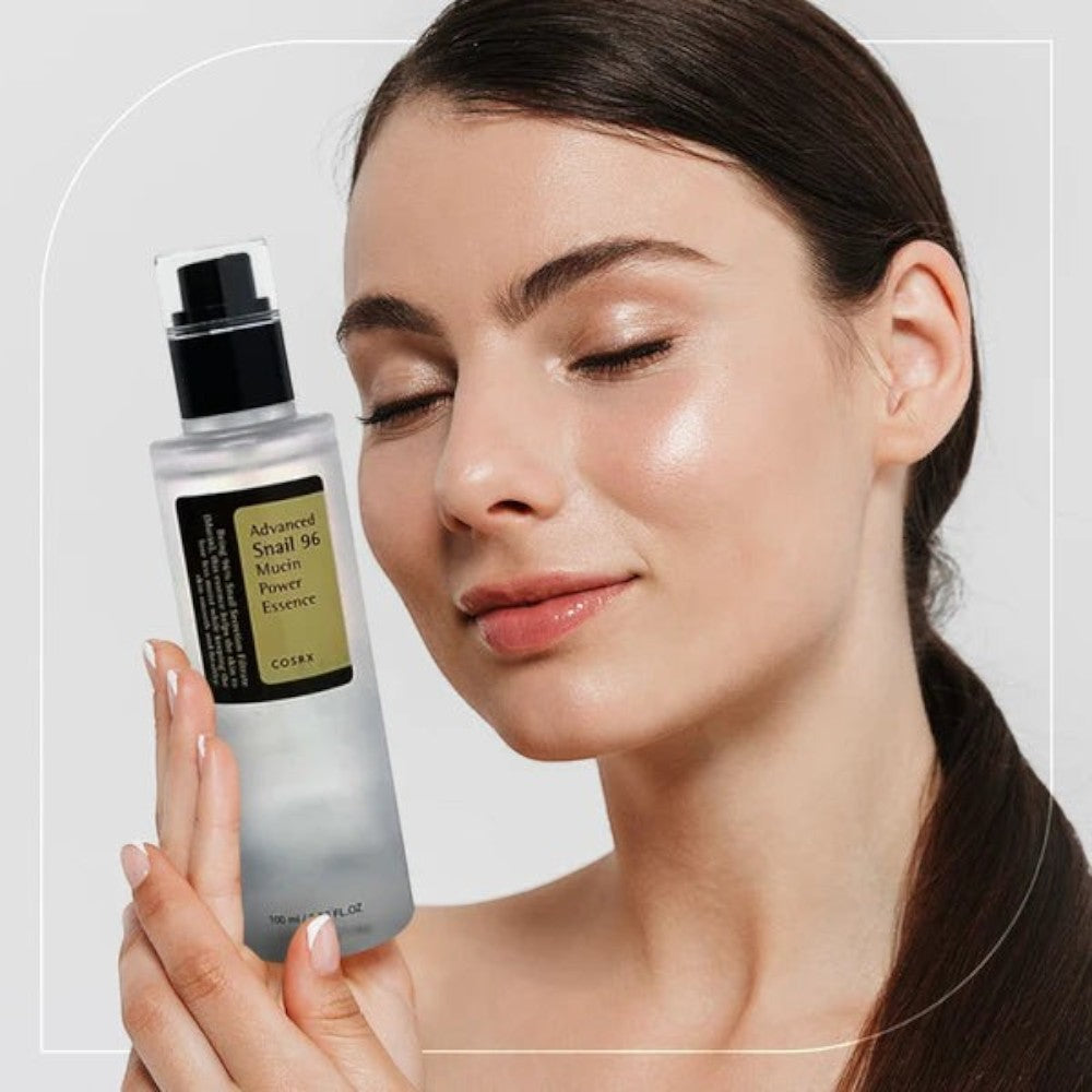 Skin TOGO model holding a bottle of Cosrx Advanced Snail 96 Mucin Power Essence for skin hydration and repair