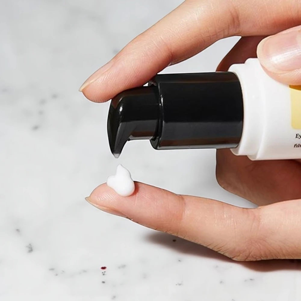 Skin TOGO Cosrx Advanced Snail Peptide Eye Cream dispensed from a pump bottle onto a finger for application