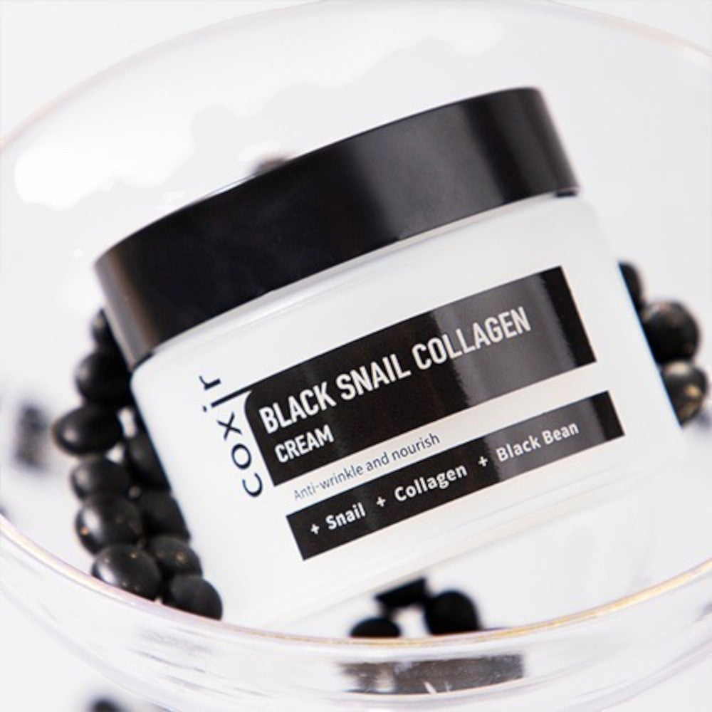 Skin TOGO Coxir Black Snail Collagen Cream jar in a glass bowl filled with black beans for anti-wrinkle skincare.