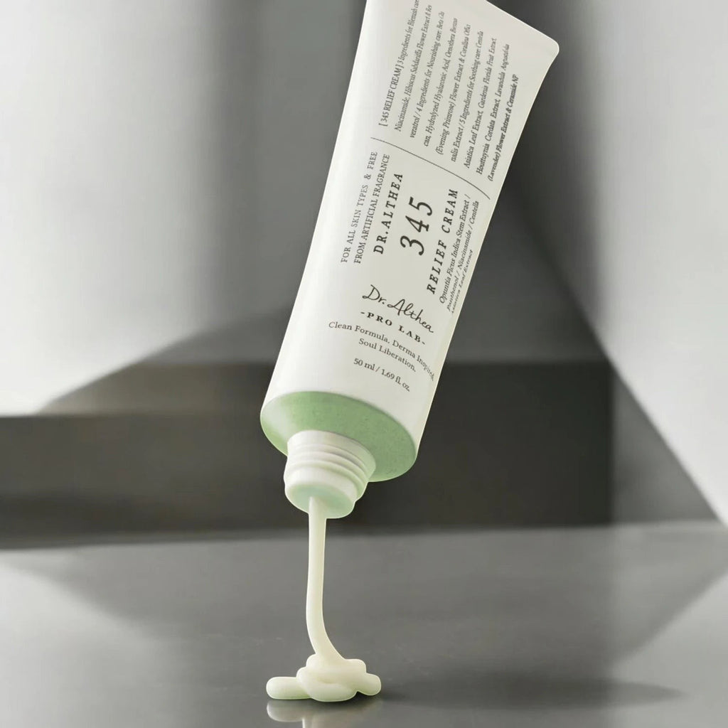 Skin TOGO Dr.Althea 345 Relief Cream tube dispensing soothing white moisturizer on a grey surface