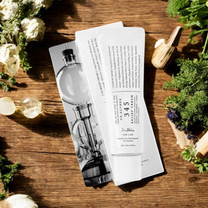 Skin TOGO Dr.Althea 345 Relief Cream tube and box on a wooden table with fresh herbs and flowers
