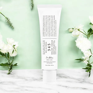 Skin TOGO Dr.Althea 345 Relief Cream in a white tube on a marble surface with white flowers against a green background