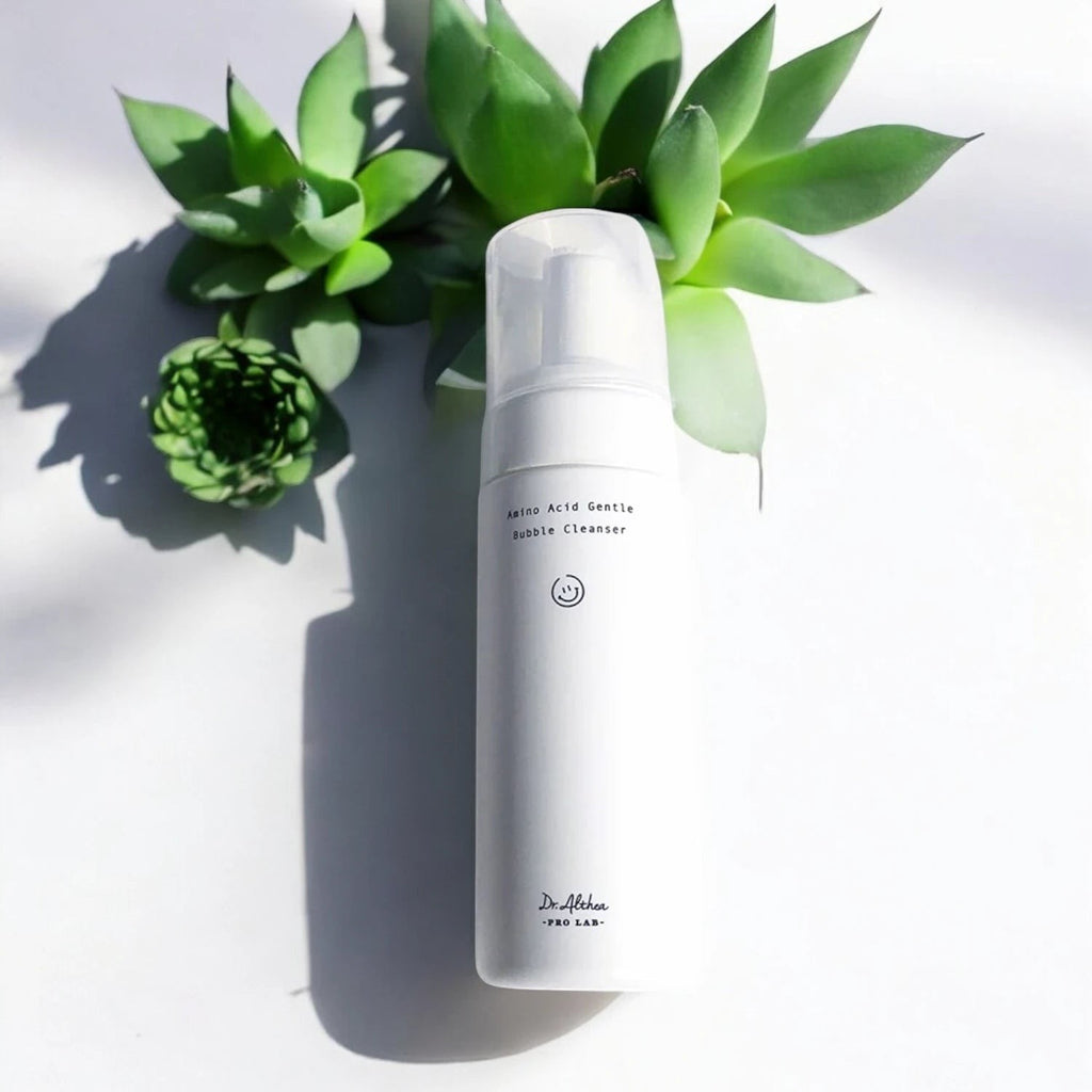 Skin TOGO Dr.Althea Amino Acid Gentle Bubble Cleanser in a white pump bottle next to green succulent plants.