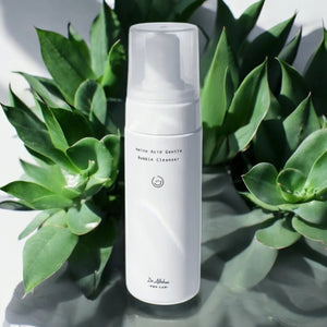 Skin TOGO Dr.Althea Amino Acid Gentle Bubble Cleanser in a white pump bottle surrounded by green succulent plants.
