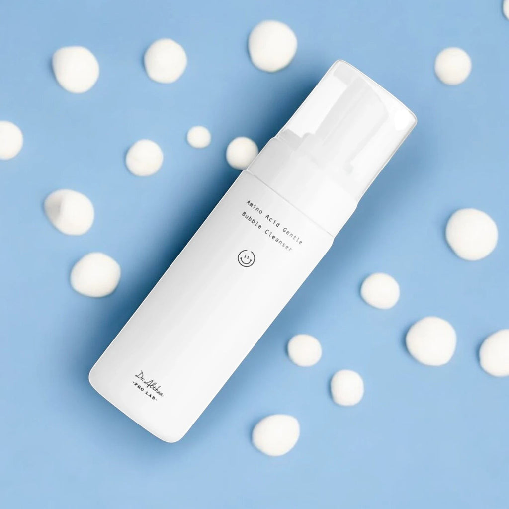 Skin TOGO Dr.Althea Amino Acid Gentle Bubble Cleanser in a white bottle surrounded by creamy foam on a blue background