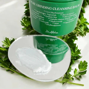 Skin TOGO Dr.Althea Pure Grinding Cleansing Balm showing the white sherbet texture on a mirror with green leaves.