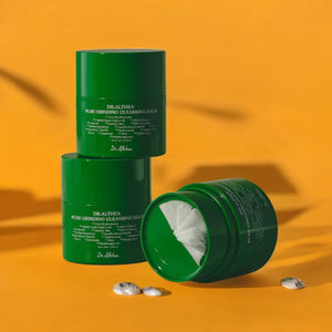 Skin TOGO Dr.Althea Pure Grinding Cleansing Balm in green jars with visible white balm texture on yellow background