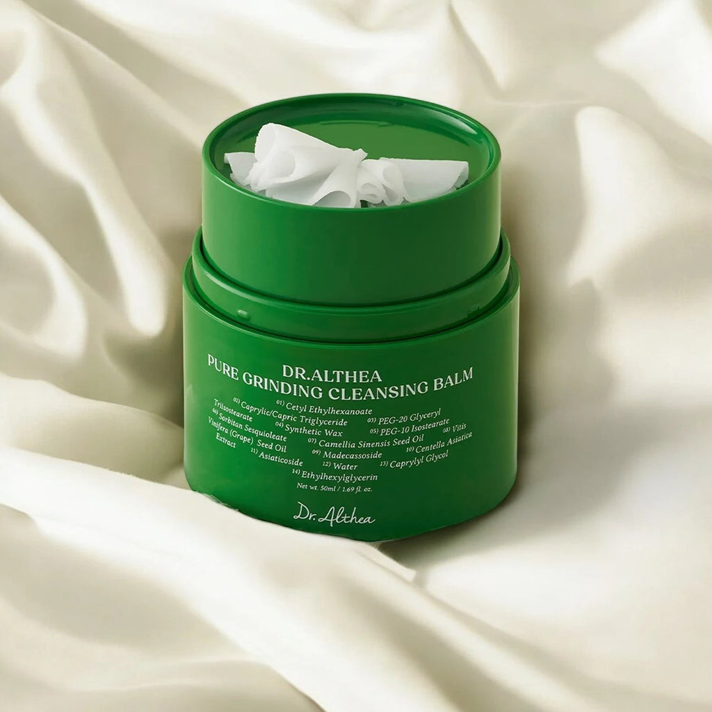 Skin TOGO Dr.Althea Pure Grinding Cleansing Balm in a green jar with a unique grinding mechanism on a white fabric.