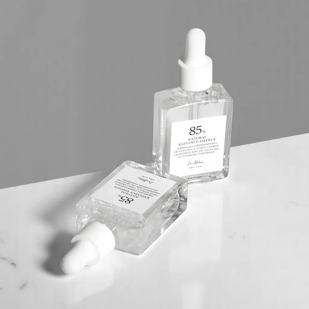 Skin TOGO Dr. Althea Natural Radiance Essence serum bottles with dropper caps on a white marble surface.