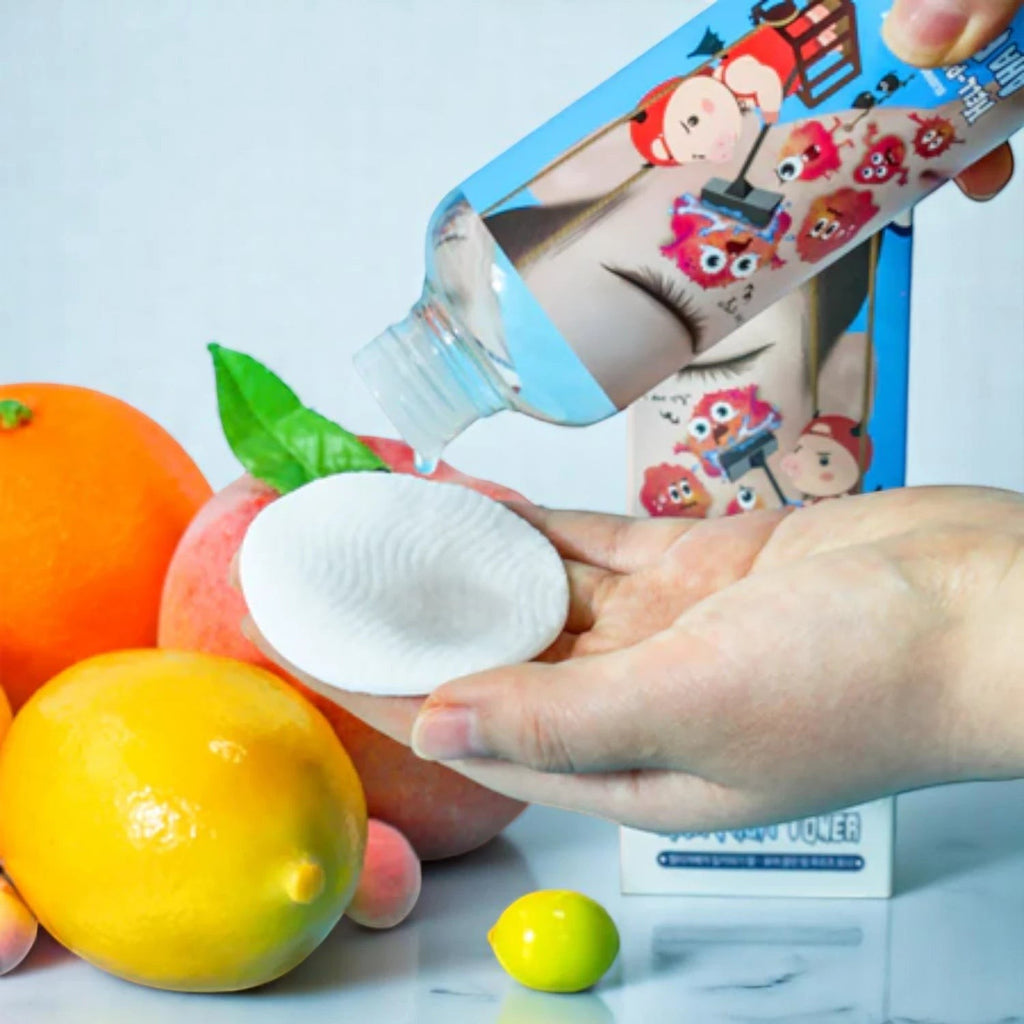 Skin TOGO Elizavecca Milky Piggy Hell-Pore AHA toner being poured onto a cotton pad with fresh citrus fruits nearby