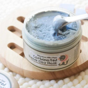 Skin TOGO Elizavecca Milky Piggy Carbonated Bubble Clay Mask in a jar with a spatula scooping grey clay texture