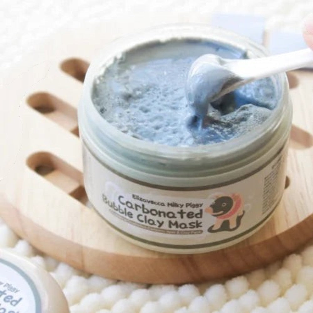 Skin TOGO Elizavecca Milky Piggy Carbonated Bubble Clay Mask in a jar with a spatula scooping grey clay texture
