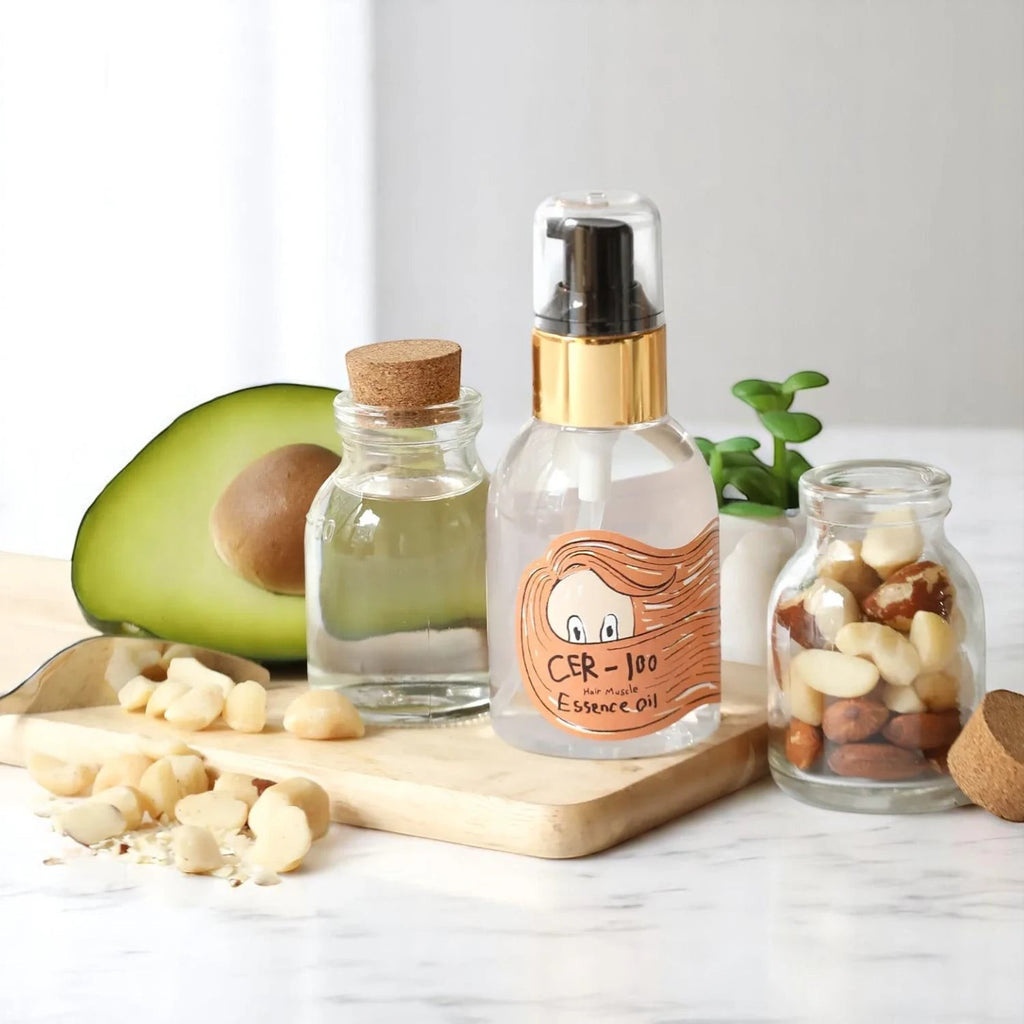 Skin TOGO Elizavecca CER-100 Hair Muscle Essence Oil bottle with avocado and macadamia nuts on a wooden board