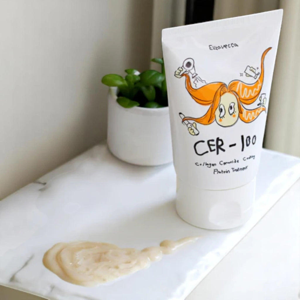 Skin TOGO Elizavecca CER-100 collagen ceramide protein hair treatment tube with a dollop of cream on a marble tray.
