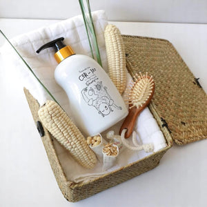 Skin TOGO Elizavecca CER-100 Collagen Coating Hair A+ Muscle Shampoo in a woven basket with corn and a hairbrush