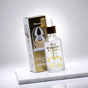 Skin TOGO Elizavecca CF-Nest 97% B-jo Serum bottle and gold box on a white marble surface for deep skin hydration.