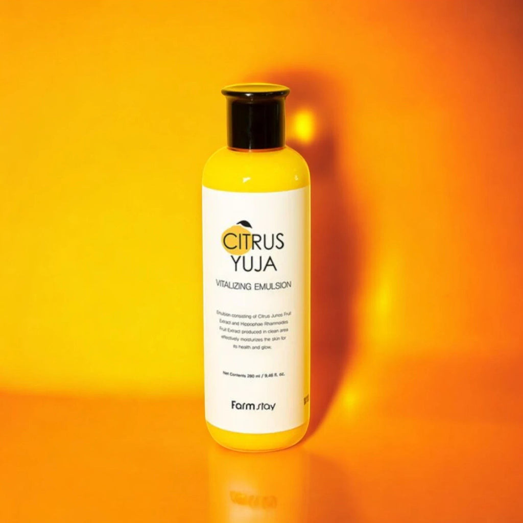 Skin TOGO Farmstay Citrus Yuja Vitalizing Emulsion in a yellow bottle against a vibrant orange background.