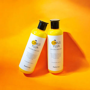 Skin TOGO Farmstay Citrus Yuja Vitalizing Emulsion bottles on a vibrant orange background for skin brightening