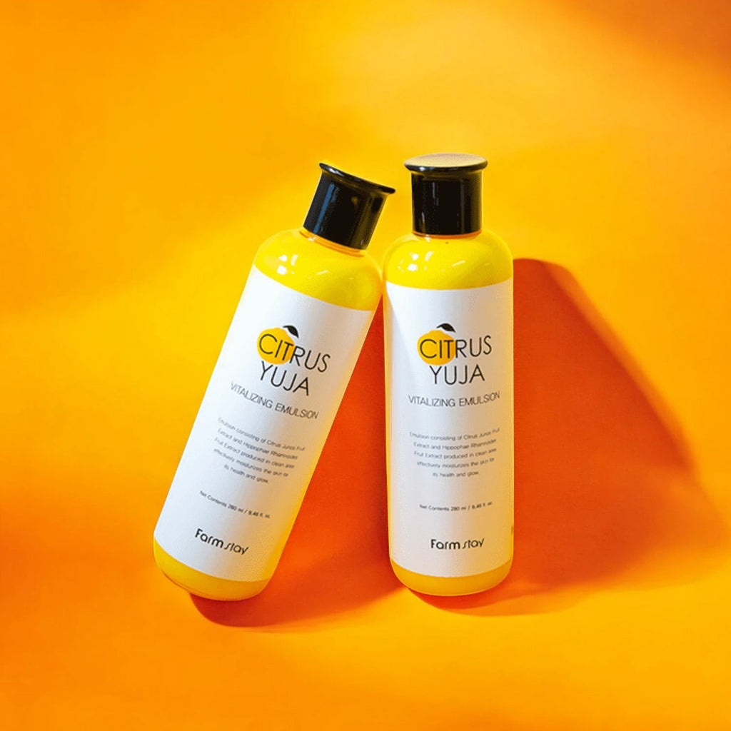 Skin TOGO Farmstay Citrus Yuja Vitalizing Emulsion bottles on a vibrant orange background for skin brightening