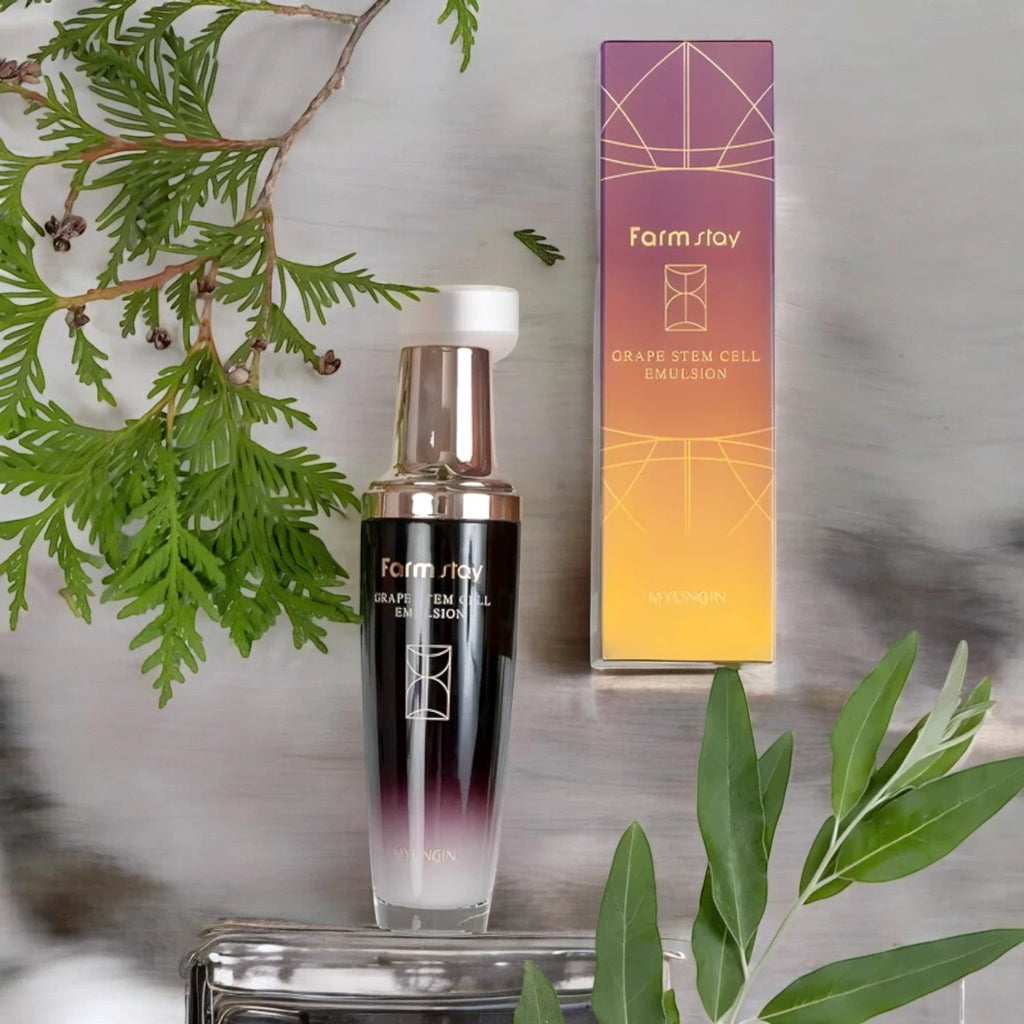 Skin TOGO Farmstay Grape Stem Cell Emulsion bottle and box with green botanical accents on a marble surface.