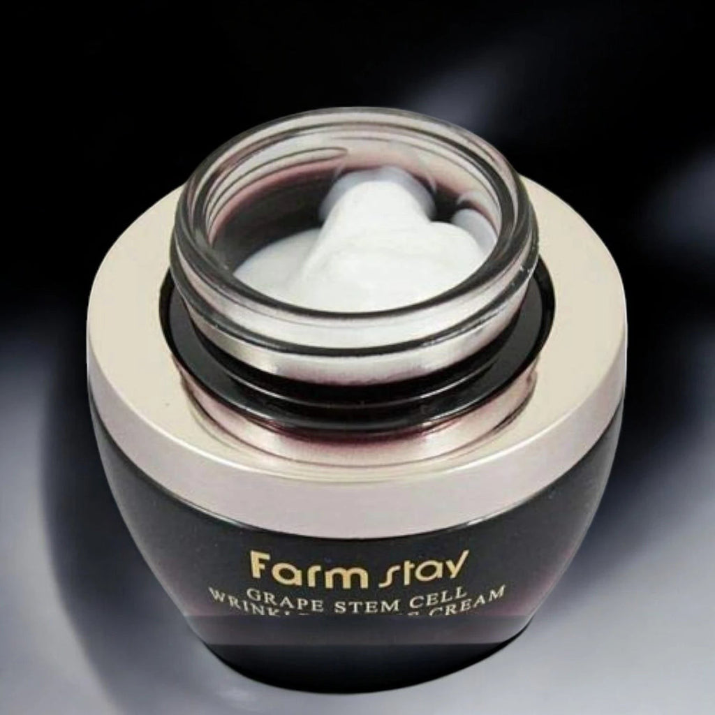 Skin TOGO Farmstay Grape Stem Cell Wrinkle Repair Eye Cream in a dark jar with a metallic lid and white cream inside.
