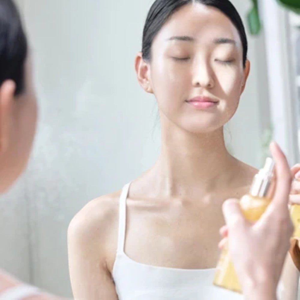 Skin TOGO Meebak Glow Serum Mist being applied to a woman's face for a refreshing vitamin boost and radiant skin