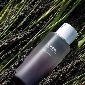 Skin TOGO Haruharu WONDER Black Rice Hyaluronic Toner bottle resting on a bed of harvested black rice stalks.