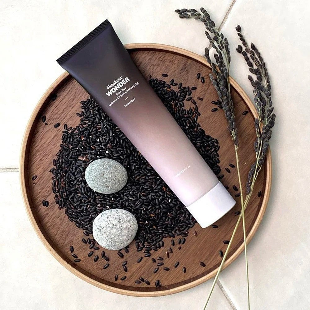 Skin TOGO Haruharu WONDER Black Rice Moisture 5.5 Soft Cleansing Gel tube on a wooden tray with black rice grains.