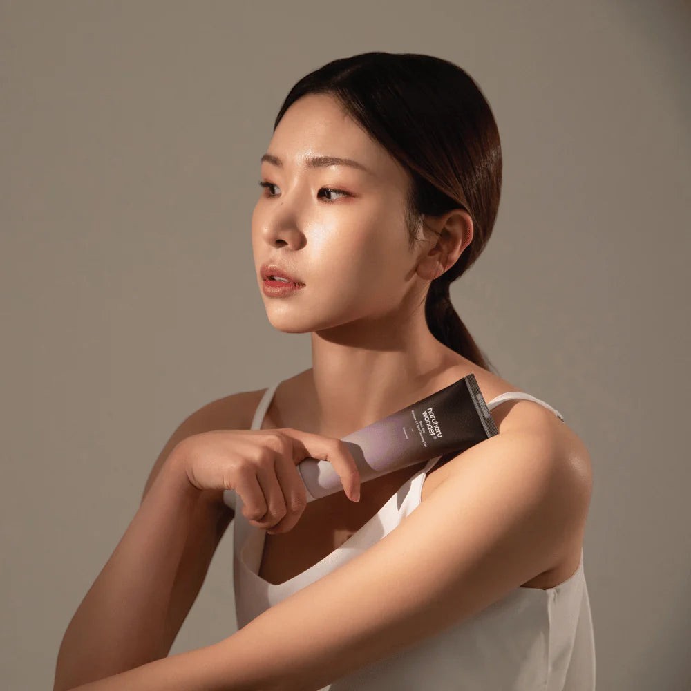 Skin TOGO model holding Haruharu WONDER Black Rice Moisture 5.5 Soft Cleansing Gel tube against a neutral background