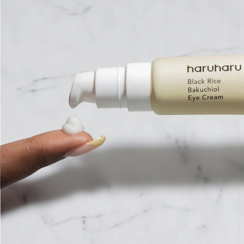 Skin TOGO Haruharu WONDER Black Rice Bakuchiol Eye Cream being dispensed onto a finger showing its creamy texture