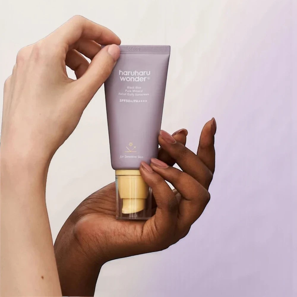 Skin TOGO Haruharu WONDER Black Rice mineral sunscreen tube held in hands, featuring SPF50+ PA++++ for sensitive skin.