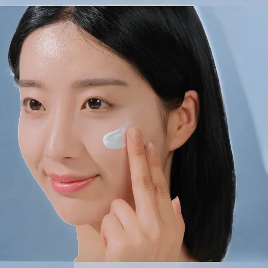 Skin TOGO model applying SKIN1004 Madagascar Centella Hyalu-Cica Water-Fit Sun Serum to her cheek