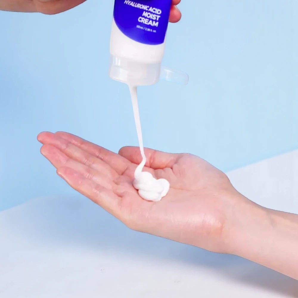 Skin TOGO Isntree Hyaluronic Acid Moist Cream being squeezed from a blue and white tube onto a person's palm
