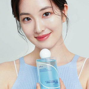 Skin TOGO model holding Isntree Ultra-Low Molecular Hyaluronic Acid Toner in a clear blue bottle for deep hydration.
