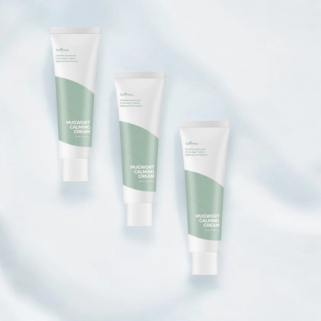 Skin TOGO Isntree Mugwort Calming Cream tubes with green accents for sensitive skin care on a soft blue background.