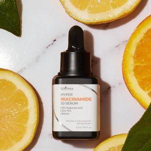 Skin TOGO Isntree Hyper Niacinamide 20 Serum bottle surrounded by fresh citrus slices on a white marble surface