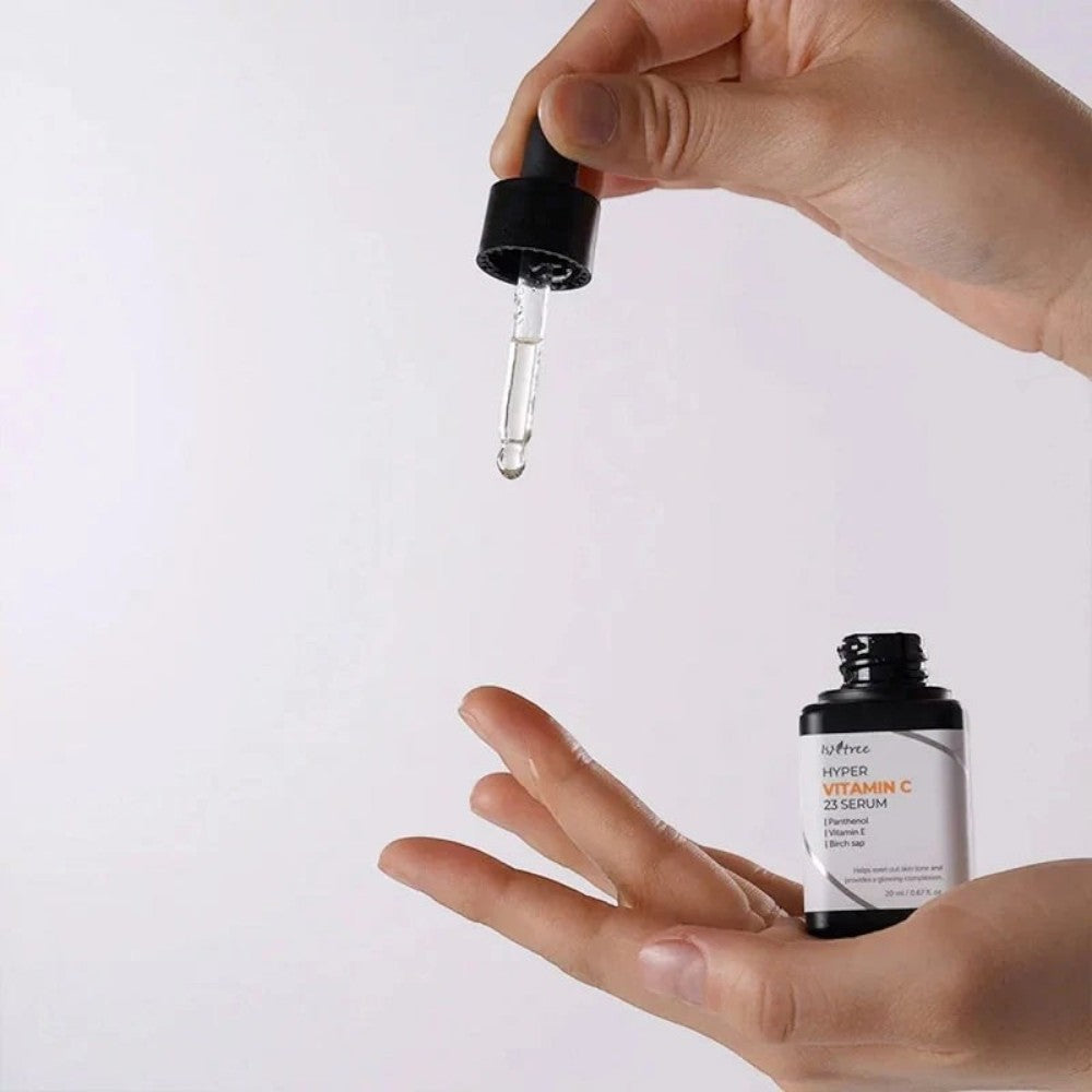 Skin TOGO Isntree Hyper Vitamin C23 Serum bottle with a dropper dispensing a clear liquid onto a hand