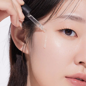 Skin TOGO Isntree Hyper Vitamin C23 serum being applied with a dropper to a woman's glowing, clear skin