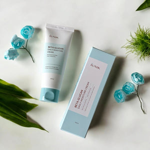 Skin TOGO iUNIK Beta Glucan Daily Moisture Cream tube and box with light blue packaging on a white surface.
