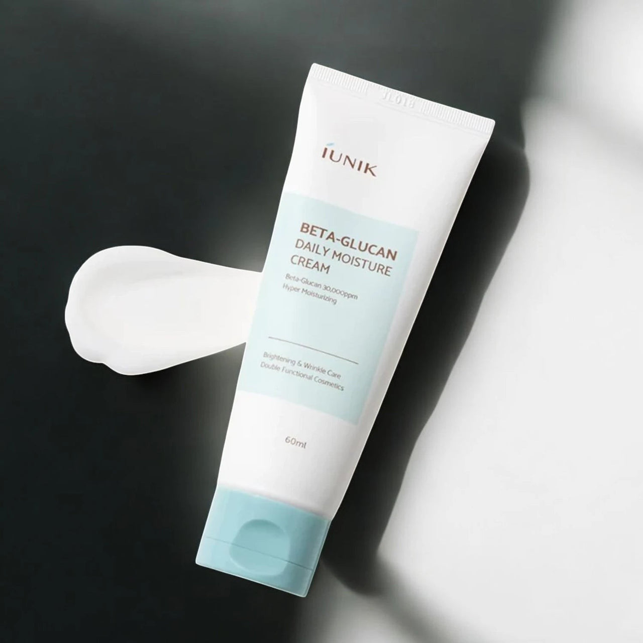 Skin TOGO iUNIK Beta Glucan Daily Moisture Cream in a white tube with a light blue cap and a swatch of white cream.
