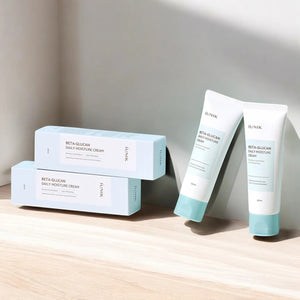 Skin TOGO iUNIK Beta Glucan Daily Moisture Cream tubes and boxes on a wooden surface with soft natural lighting.