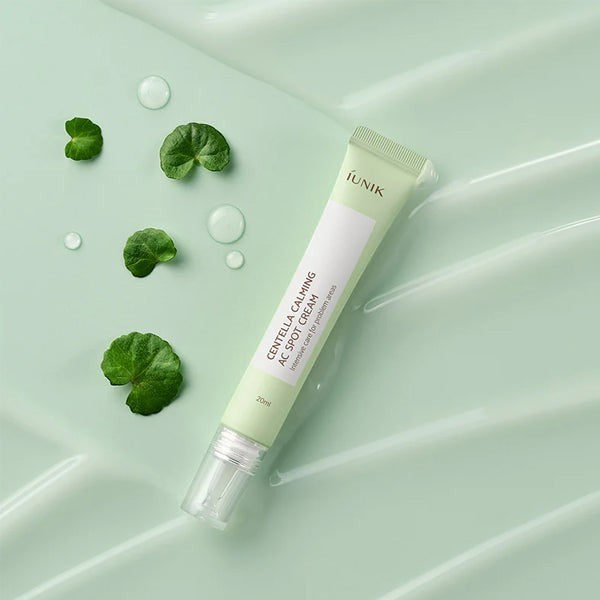 Skin TOGO iUNIK Centella Calming AC Spot Cream in a light green tube with centella leaves on a soft green background.