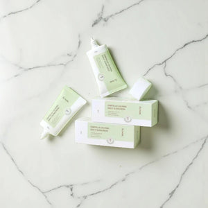 Skin TOGO iUNIK Centella Calming Sun Cream tubes and boxes on a white marble surface