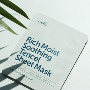Skin TOGO Dear, Klairs Rich Moist Soothing Tencel Sheet Mask in white packaging with blue text, set against a leaf shadow.