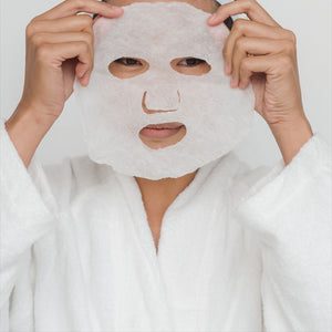 Skin TOGO Lebelage Propolis Solution sheet mask applied to a person wearing a white bathrobe for skincare routine