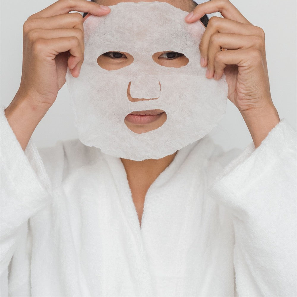 Skin TOGO Lebelage Propolis Solution sheet mask applied to a person wearing a white bathrobe for skincare routine