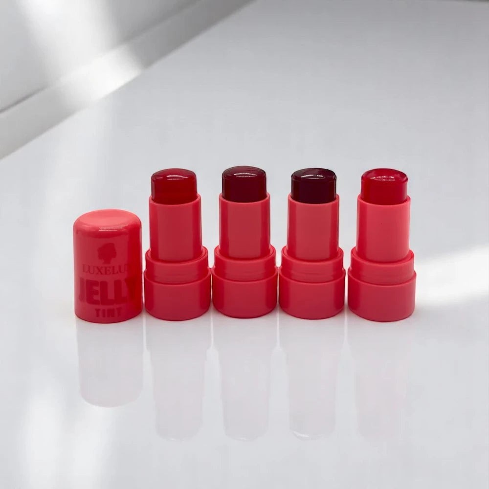 Skin TOGO Luxelux jelly tint sticks in various pink and berry shades arranged in a row on a white surface.