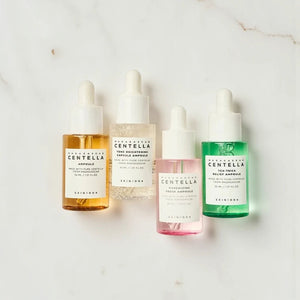 Skin TOGO Madagascar Centella Ampoule Kit featuring four different skincare serums on a marble surface.