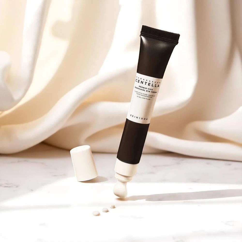 Skin TOGO Madagascar Centella Probio-Cica Bakuchiol Eye Cream tube with dispensed cream on a white marble surface.