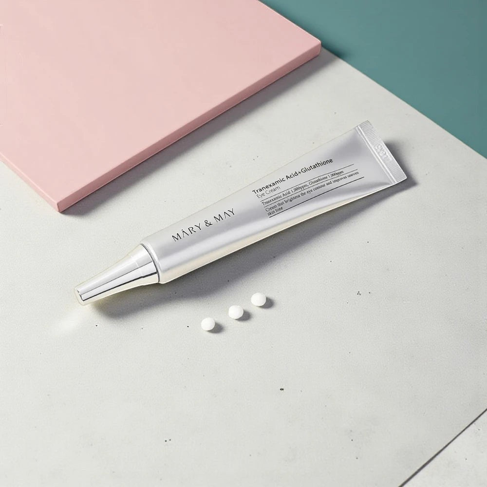 Skin TOGO Mary&May Tranexamic Acid + Glutathione eye cream tube with three cream dots on a minimalist surface.
